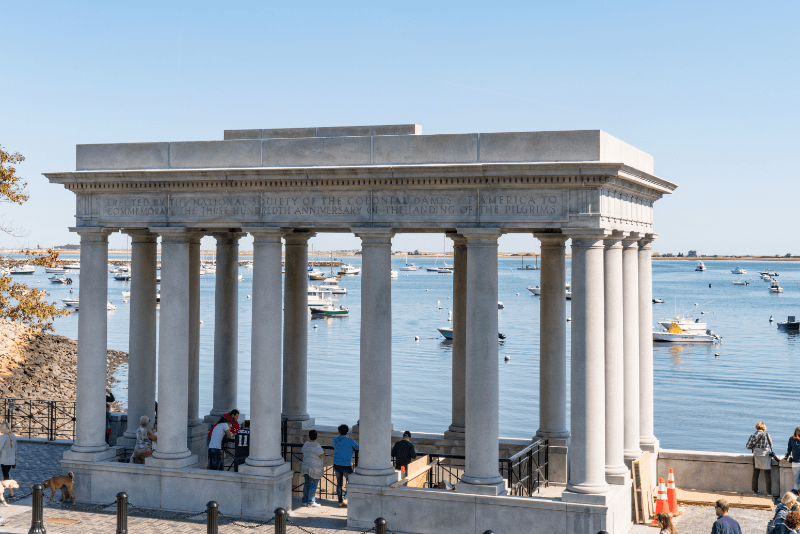 View of the portico over Plymouth Rock with water in the background.