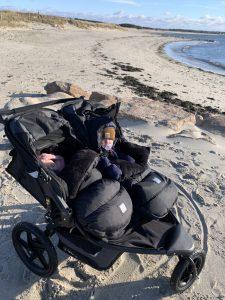 baby and toddler in stroller on beach 