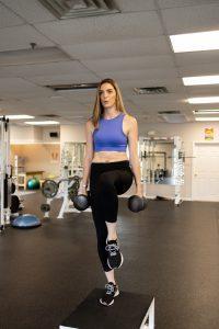 Woman lifting weights in a gym