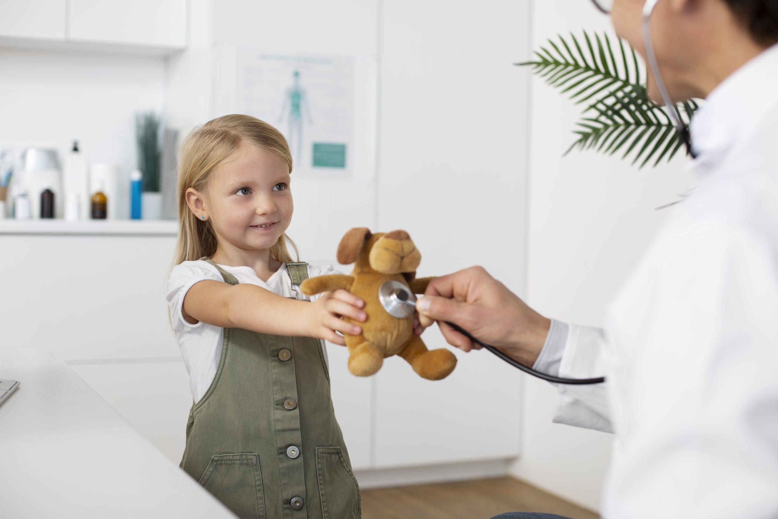 doctor using a stethoscope to examine a child holding a teddy bear, navigating severe food allergies in kids