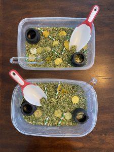 two sensory bins with gold coins and other items